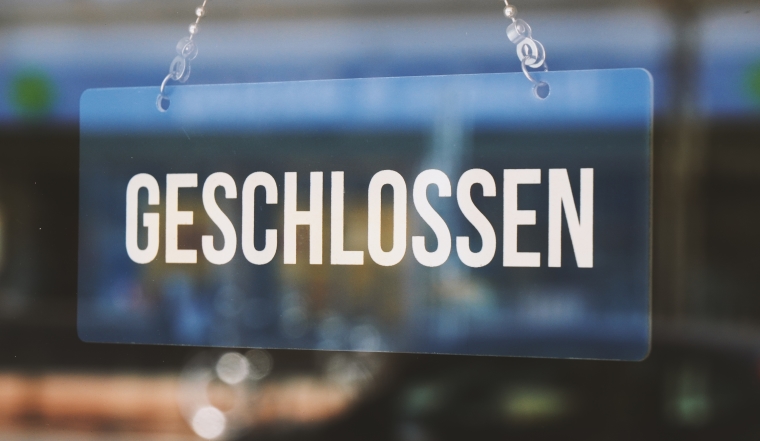 sign geschlossen - closed in german - economy crisis or business closure concept
