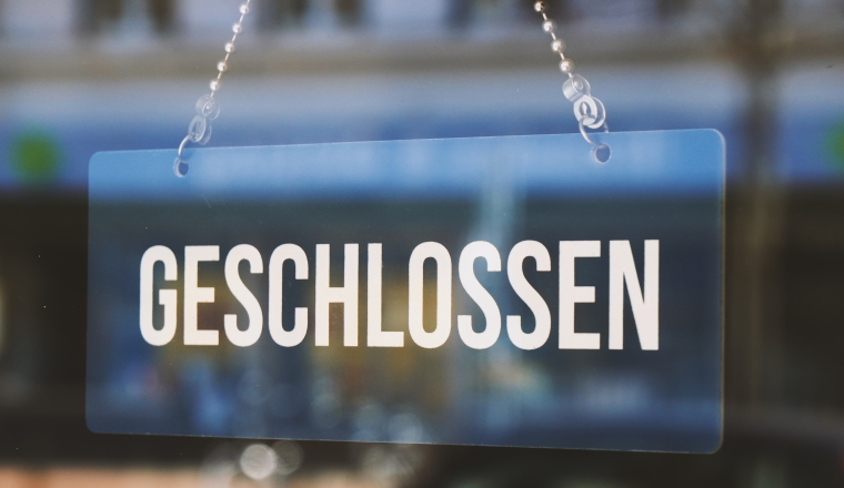 sign geschlossen - closed in german - economy crisis or business closure concept