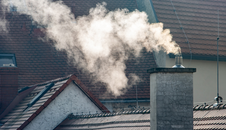 Smoke rising from the chimney in city