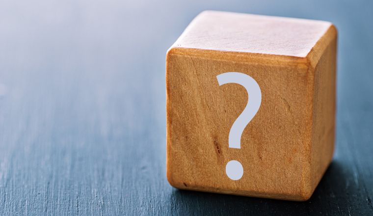 A question mark is printed on a wooden block, the concept of thinking, doubting and looking for an answer.
