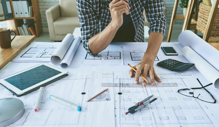 Cropped image of architect working with construction plans