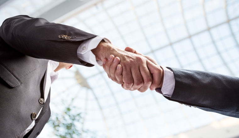 Handshake. Closeup shot of hands. The business center on the background.