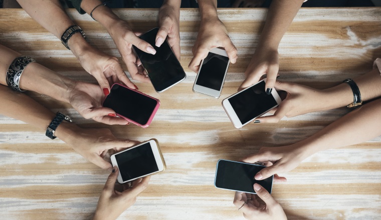 Top view hands circle using phone in cafe.