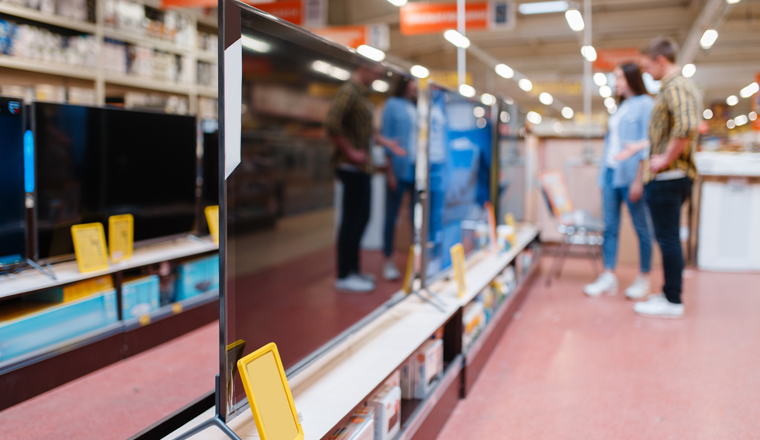 Family couple at the shelf with plasma TV in electronics store. Man and woman buying home electrical appliances in market