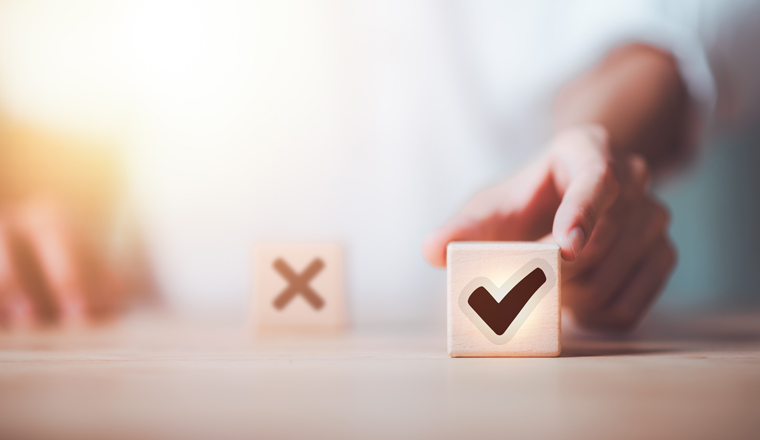 businessman selects wooden block with check mark icon symbol ,best alternative decision idea ,solution that has been analyzed ,Looking for new paths and opportunities ,Qualification for Measurement