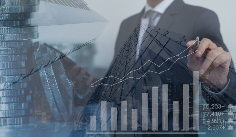 Double exposure, businessman using  tablet with skyscraper and financial graph on financial background, business trading, business strategy analysis, economic growth report concept