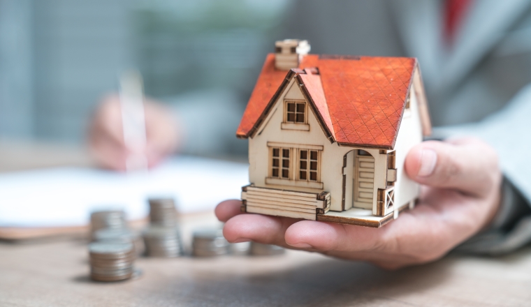 Businessman as a property agent or investor calculating growth of return on investment in real estate before signing contract at the office