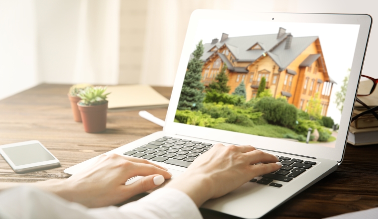 Online shopping concept. Woman looking for house on real estate market website
