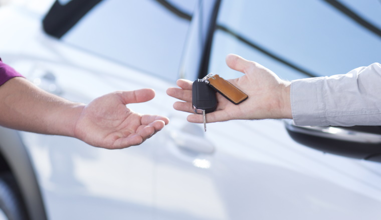 Panorama and close-up of car seller's hand with keys and buyer's hand after transaction