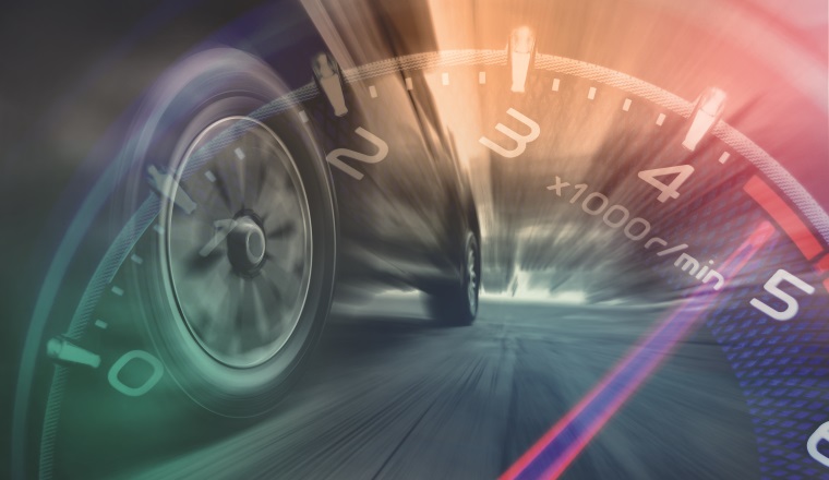 Tires is spin of speeding car with gauge. Low angle side view of car driving fast on motion blur