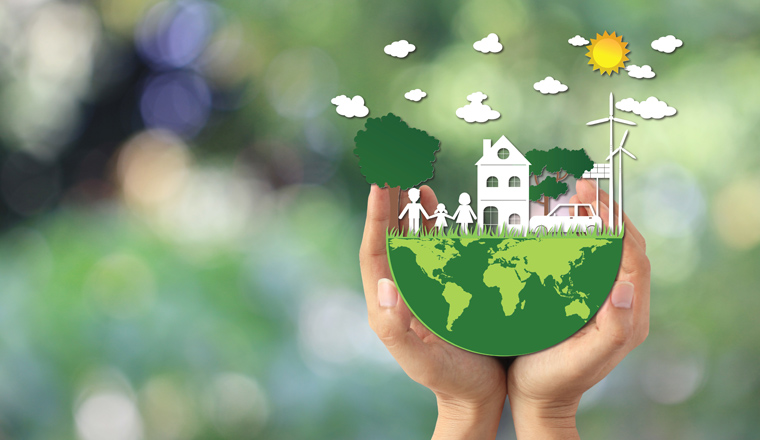 Man hand holding green world with model house and model family on natural green background, We love the world of ideas