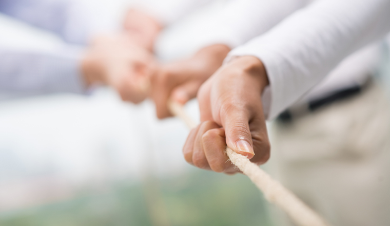 Concept image of business team using a rope as an element of the teamwork on the foreground 