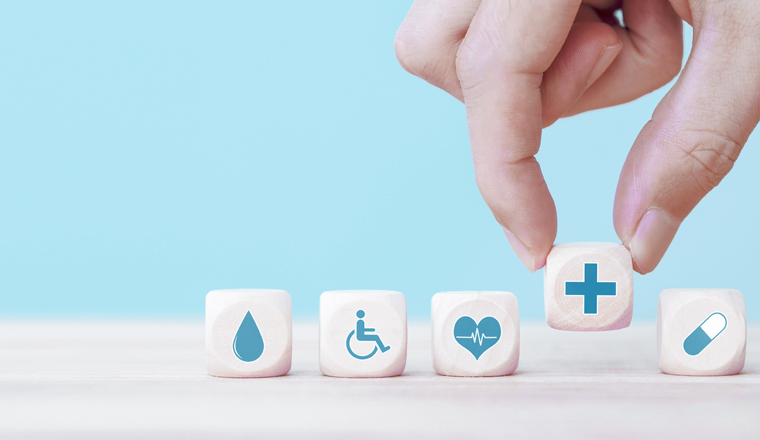 Hand chooses a emoticon icons healthcare medical symbol on wooden block , Healthcare and medical Insurance concept
