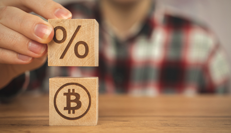 Bitcoin and taxes concept background, us taxation. Wooden cubes with bitcoin and percent symbols in hands close-up view business