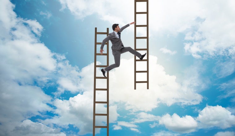Businessman climbing career ladder in business concept