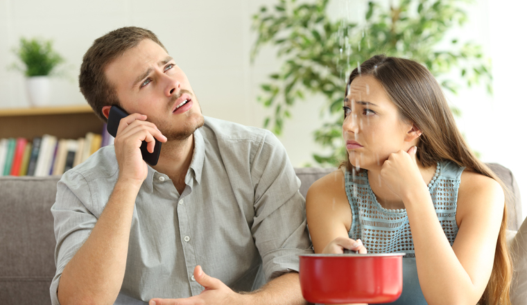 Desperate couple callling to insurance worried about home leaks in the living room