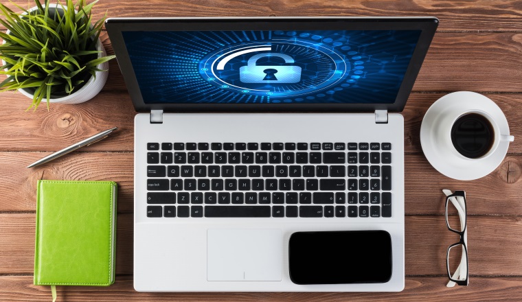 Business workplace with office stuff and laptop with padlock icons on screen