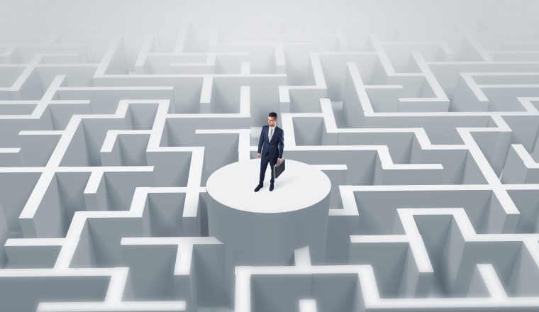 Businessman standing on the top a maze and looking through