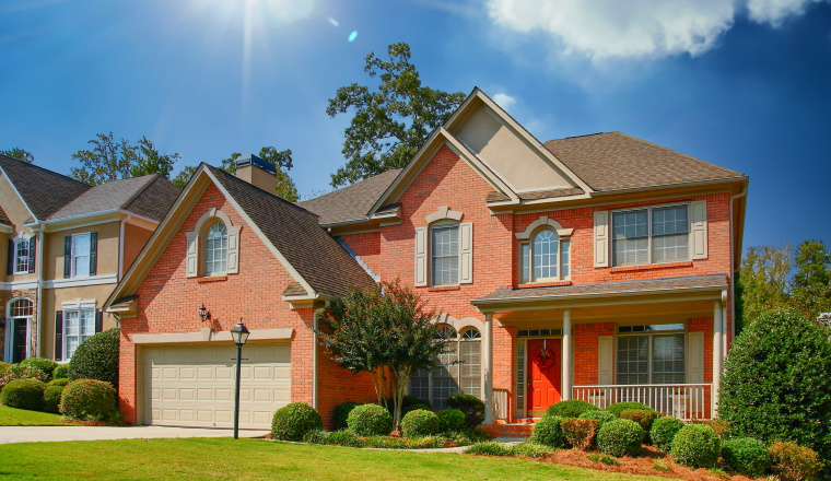 A nice brick home on a grassy lot with a red door