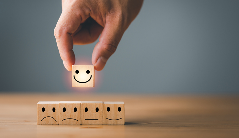 Customer service and Satisfaction concept ,Business people show a feedback with smile face wood cube happy Smiley face icon to give satisfaction in service. rating very impressed.