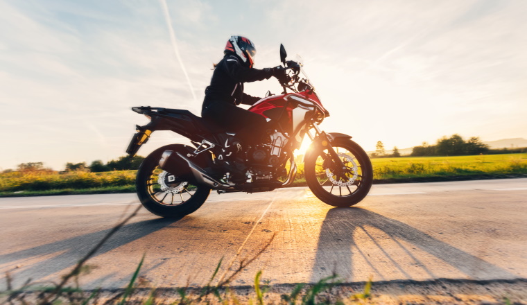 Fast motorcycle drive on asphalt road at sunset. Speed and motion