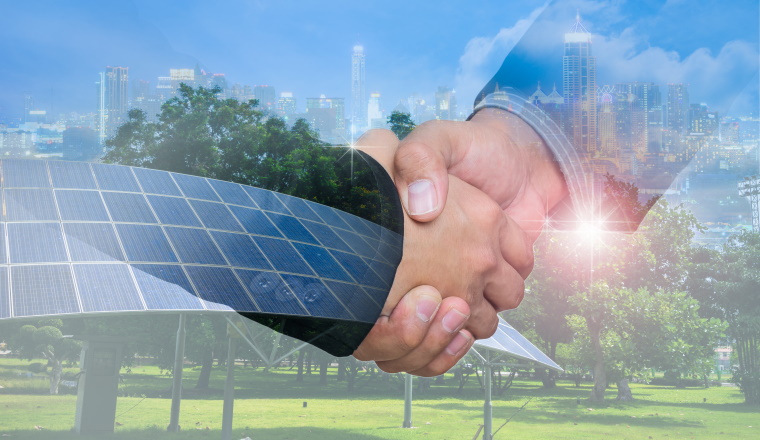 Double Exposure of a businessman handshake on the background blurred downtown nightlife. Concept of an agreement green energy.