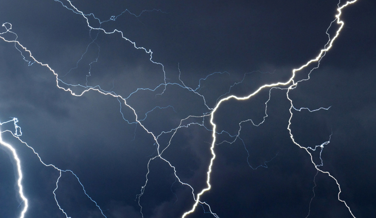 Fork lightning striking down during summer storm.