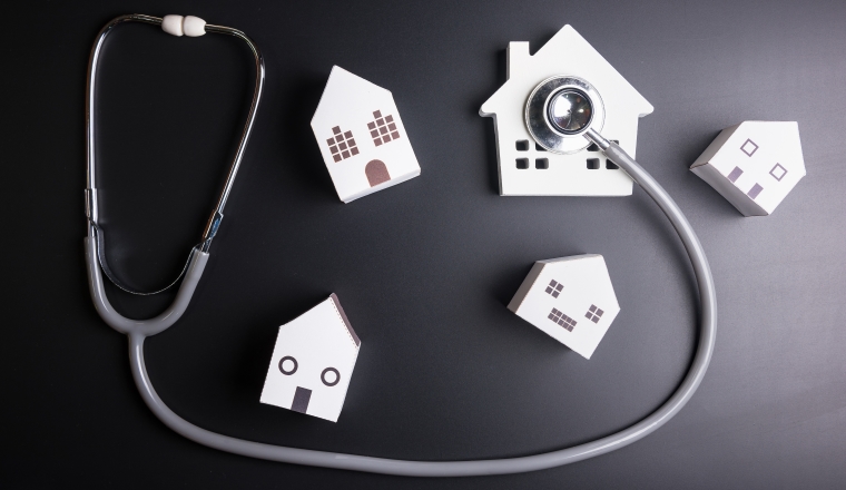 House model with stethoscope isolated on black background.Indicates the health of the house