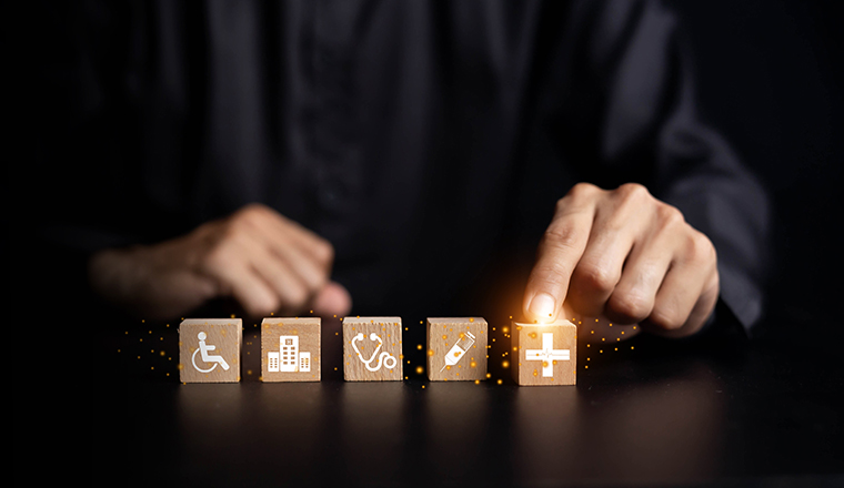 Hand arranging wood block with healthcare medical icon. Health insurance - concept.