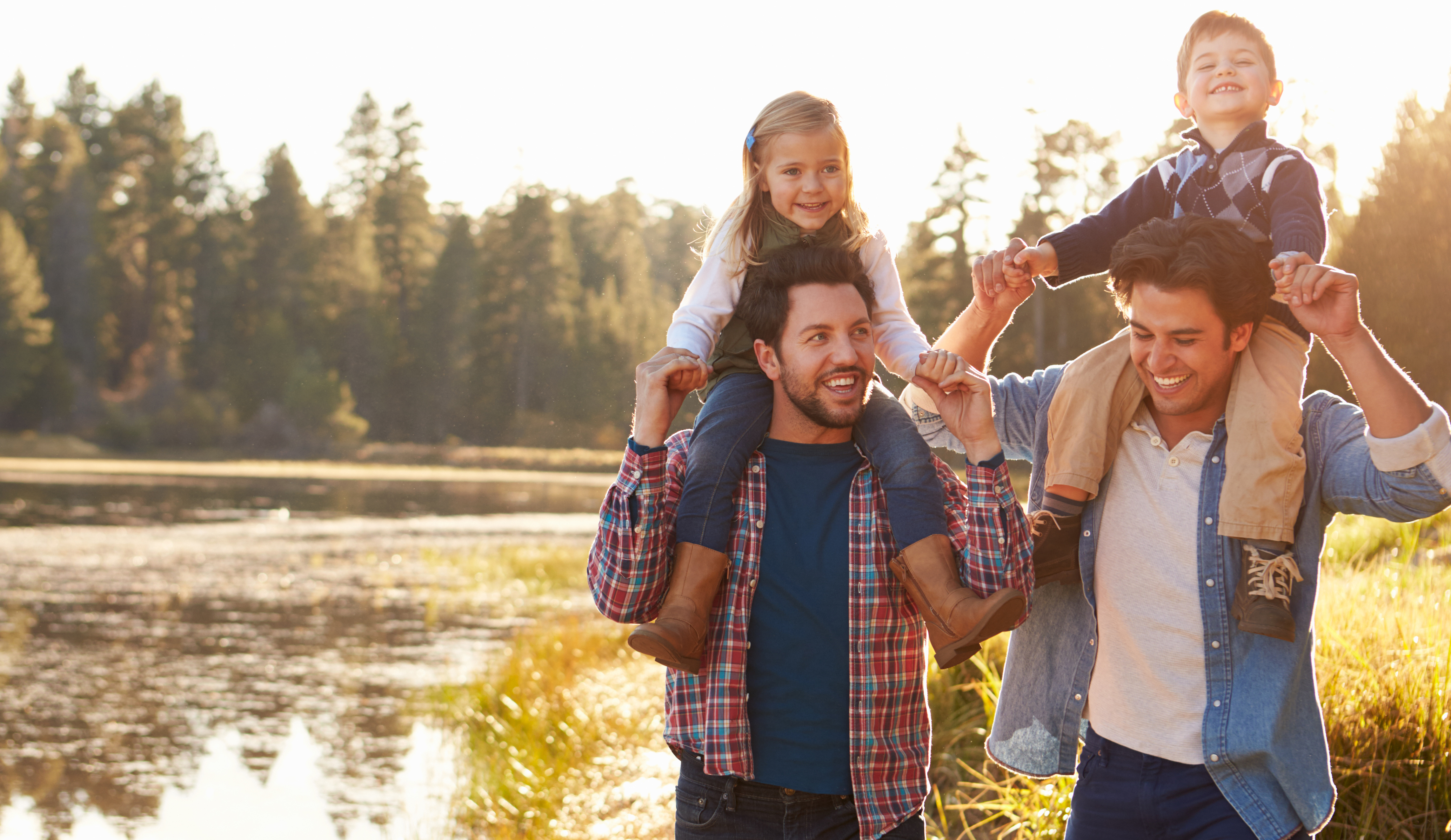 Gay Male Couple With Children Walking By Lake