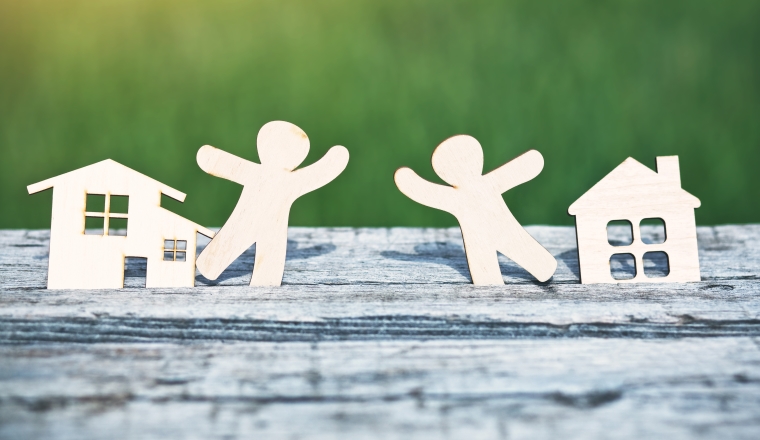 little wooden men in houses. Symbol of neighborhood, friendship, teamwork and sweet home concept