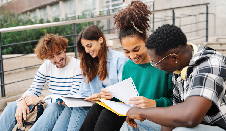 University students sitting on university stairs working and learning together