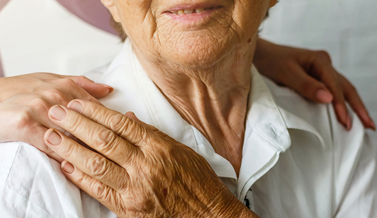 Elderly female hand holding hand of young caregiver at nursing home.Geriatric doctor or geriatrician concept. Doctor physician hand on happy elderly senior patient to comfort in hospital examination