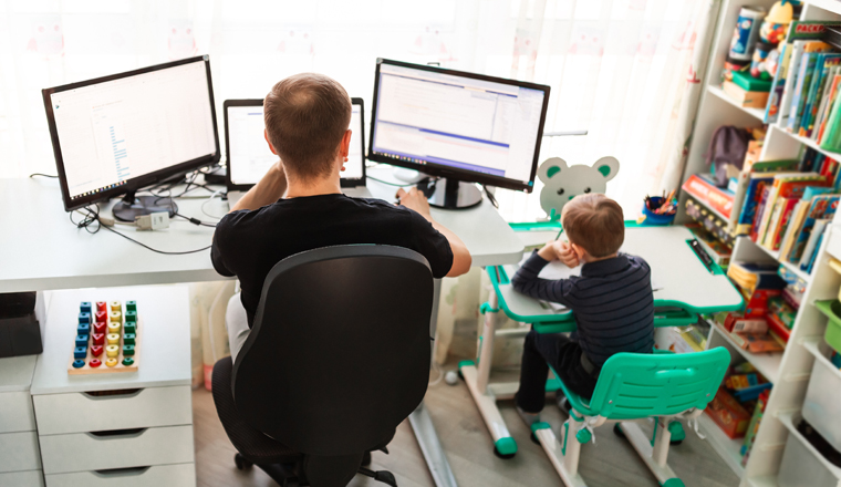 Father with kid trying to work from home during quarantine. Stay at home, work from home concept during coronavirus pandemic