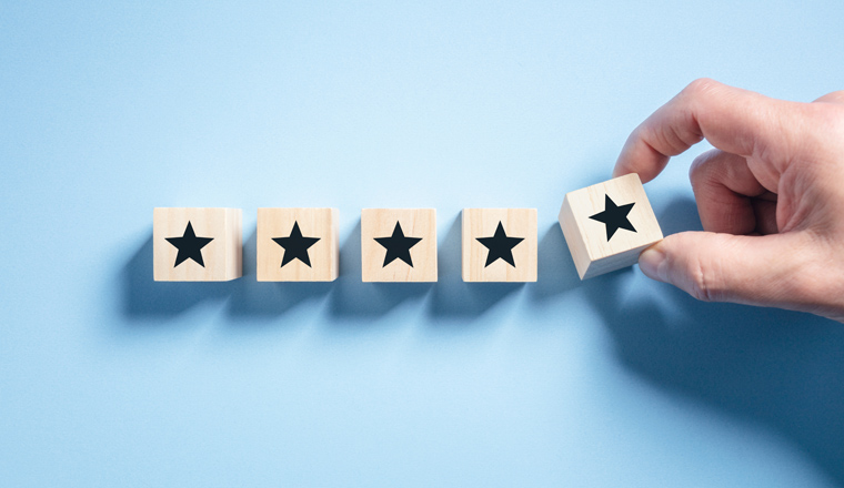 Customer experience feedback rate satisfaction experience five star rating placing wooden blocks on blue background