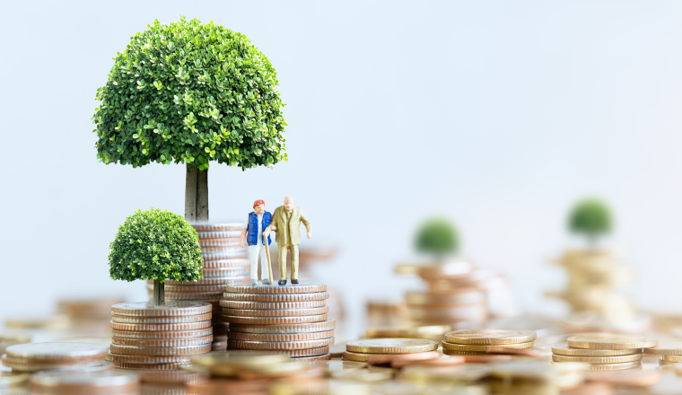 Miniature people: Elderly people sitting on coins stack. social security income and pensions. Money saving and Investment. Time counting down for retirement concept.