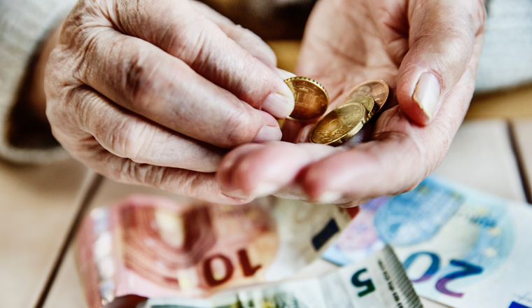 Hand einer Seniorin mit Bargeld, Seniorin zählt ihr Geld