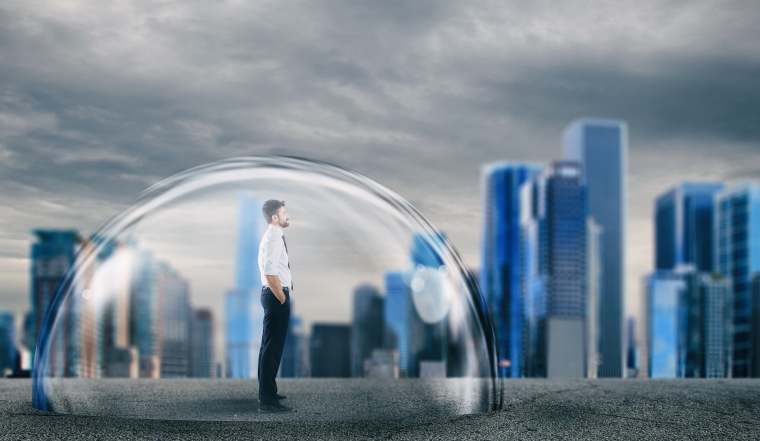 Businessman inside a transparent sphere that protects him.