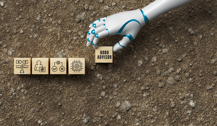 robot hand adding a cube with the text ROBO ADVISOR to a stack of cubes with business icons on dirt gravel background