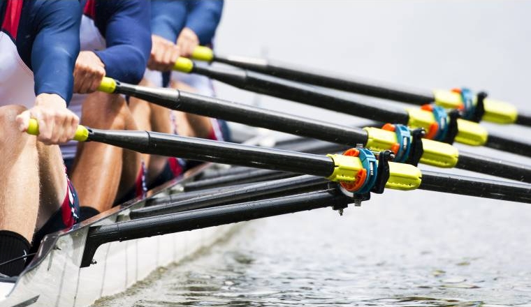 Close up of a men's quadruple skulls rowing team, seconds after the start of their race