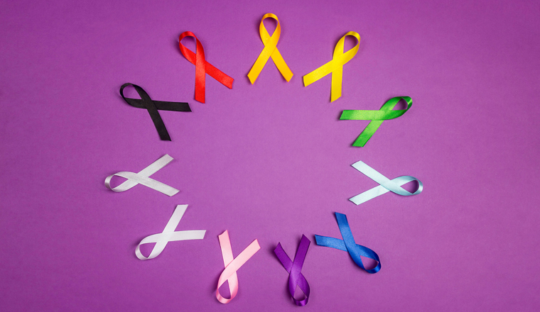 World cancer day concept, February 4. Circle of colorful awareness ribbons on  purple background. Copy space for text. Healthcare and medicine concept. 