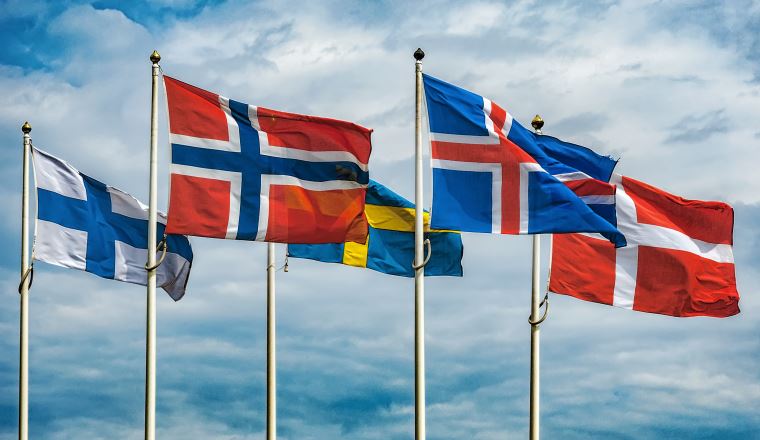 The flags of the countries of Scandinavia waving in the sky of a beautiful summer day.