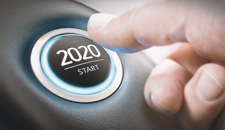 Finger about to press a car ignition button with the text 2020 start. Year two thousand and twenty concept.