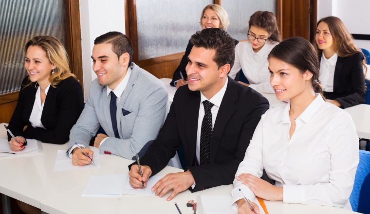 Positive professor and young professionals at  business courses indoors