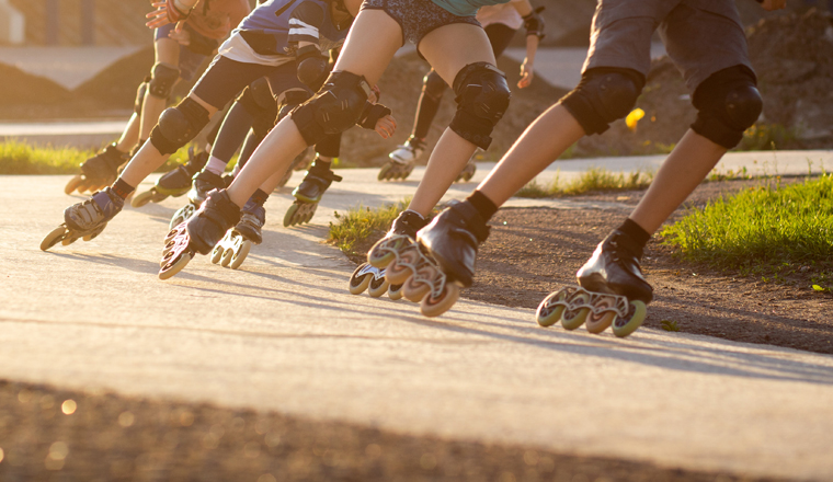 Group of teenagers skating on track in summer evening. Abstract panoramic short track speed skating sport background