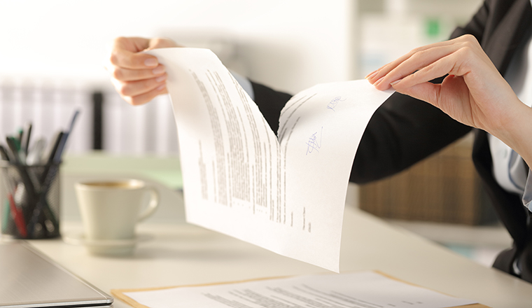 Business woman hands breaking document at the office