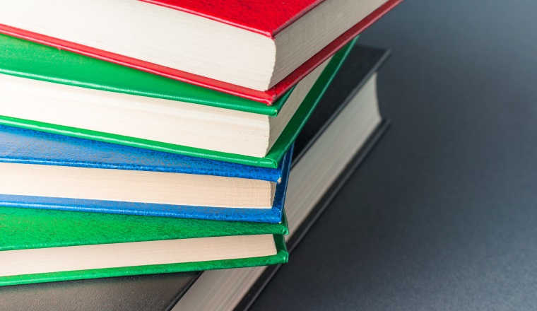 Beautiful colorful books lie on a gray background.