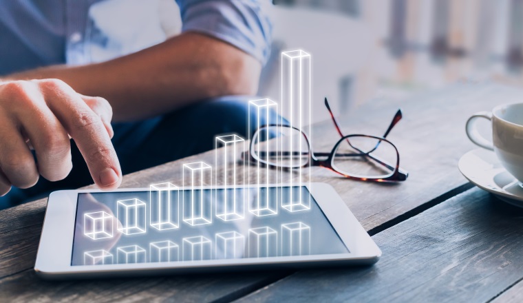 Businessman analyzing growing 3D AR chart floating above digital tablet computer screen, showing successful increase in business profit