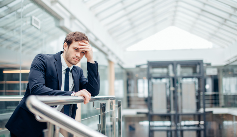 Young sad businessman covering his face with his hand. Man got bad news.Stress