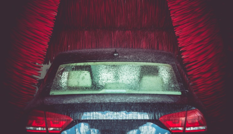 Automatic Brush Car Wash in Action. Elegant Modern Full Size Car in the Car Wash.